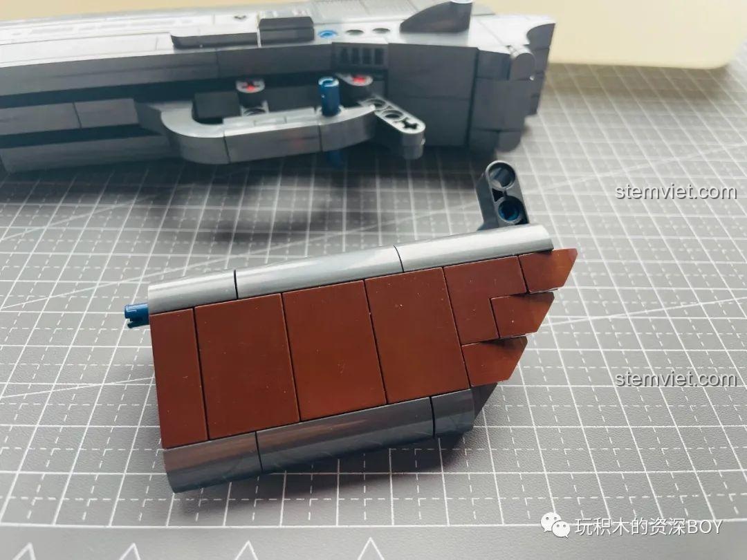 Mô hình súng lục PanlosBrick 670007 M1911 đã hoàn thành, đặt cạnh hộp sản phẩm để so sánh độ chân thực.