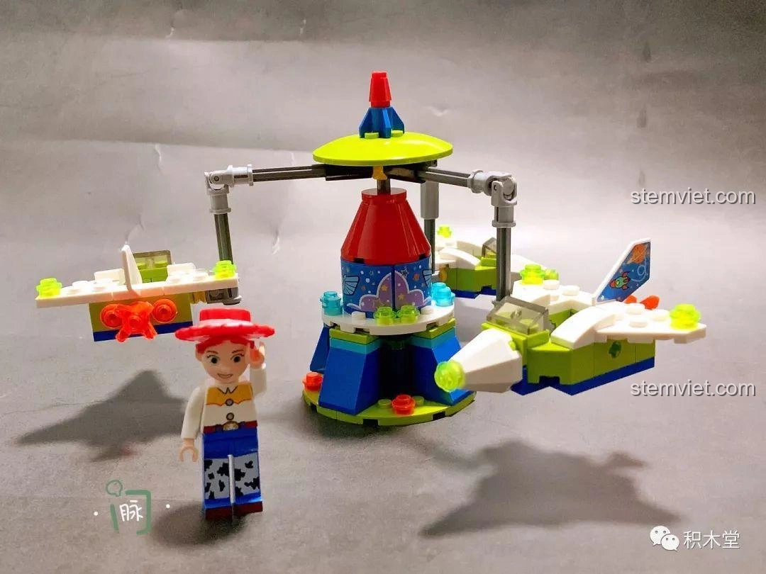 Mô hình Tàu Lượn Trên Không Của Jessie hoàn chỉnh, với Jessie đứng cạnh, các máy bay nhỏ xoay quanh một trụ trung tâm.