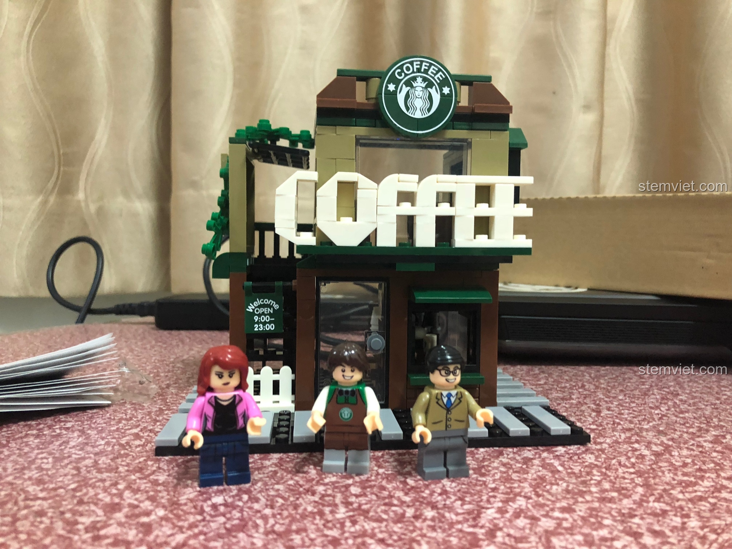 Mô hình tiệm cà phê Sembo 601019 đã hoàn thành với 2 tầng và 3 minifigures đứng phía trước.