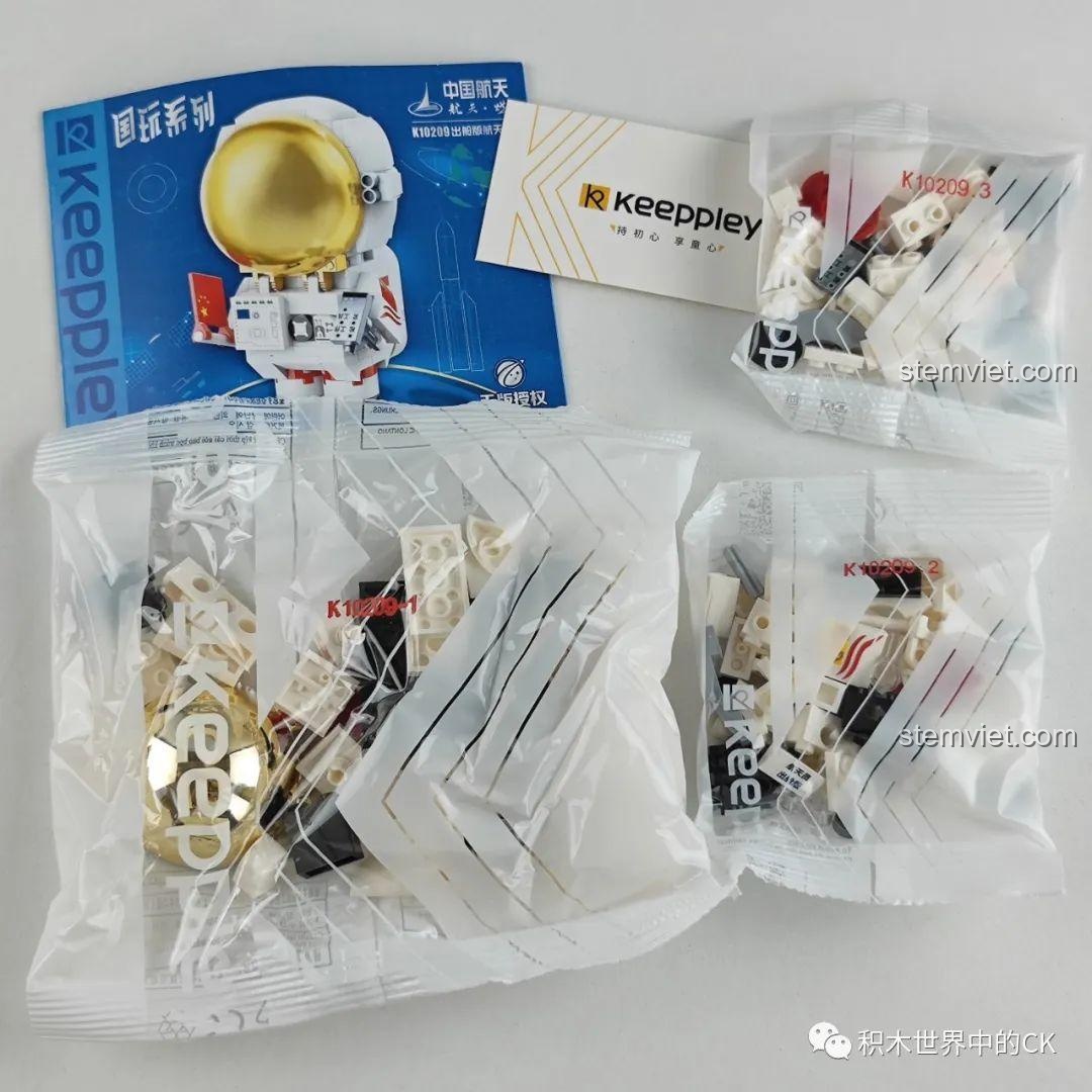 Các túi mảnh ghép, sách hướng dẫn và thẻ của bộ Keeppley K10209 phi hành gia được sắp xếp gọn gàng.