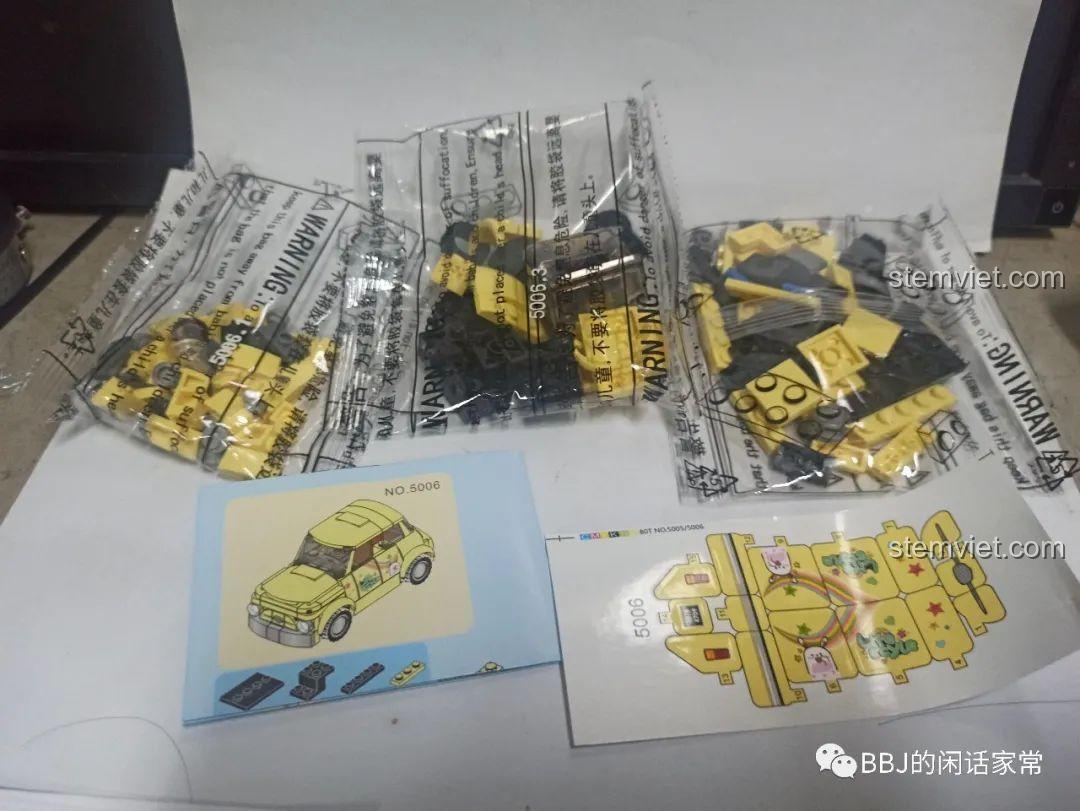 Mở hộp bộ lắp ráp Xe Fiat 500 SY 5006, bên trong có các túi mảnh ghép, sách hướng dẫn và sticker.