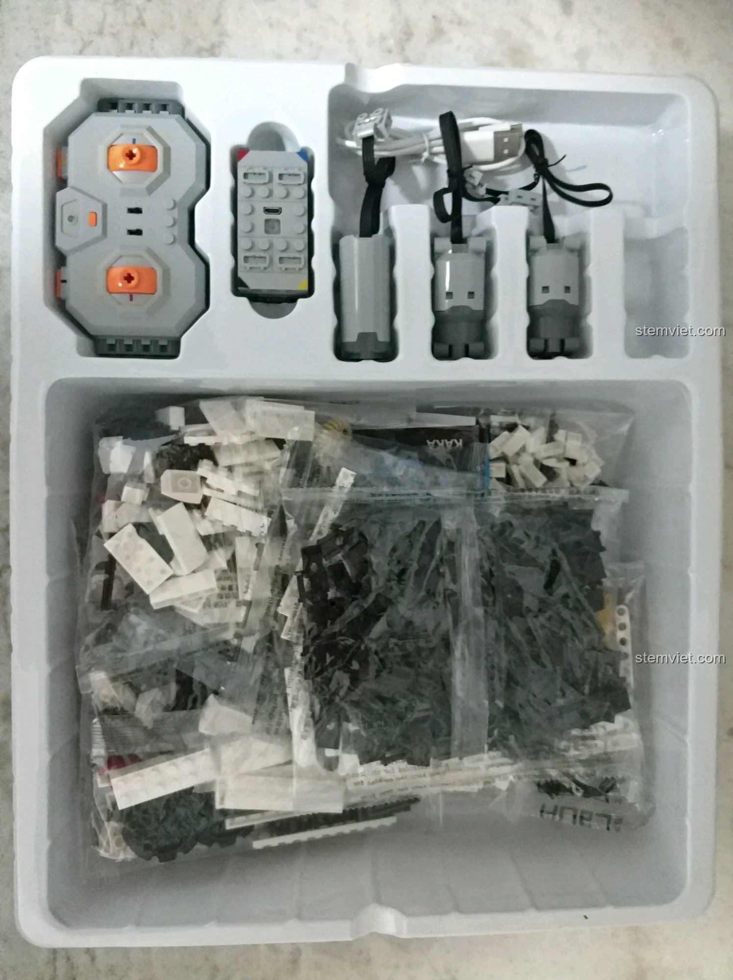 Bên trong hộp CaDA C51027 Robot KAKA với khay nhựa định hình chứa các chi tiết, động cơ và điều khiển.