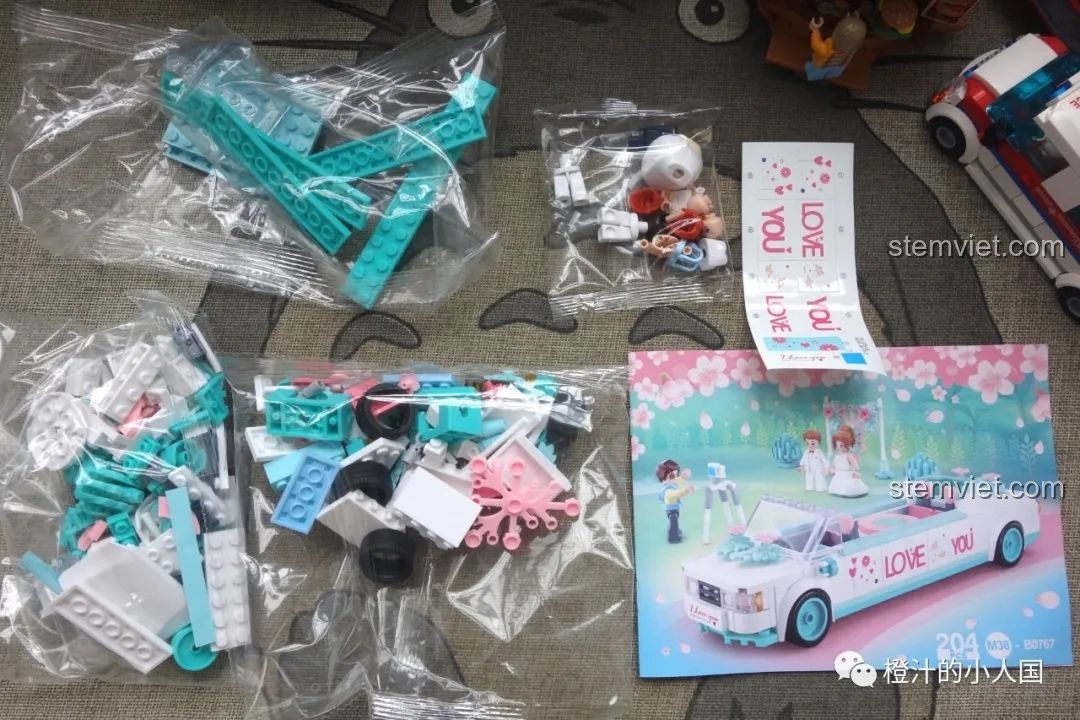 Bên trong hộp đồ chơi lắp ghép Xe hoa đám cưới B0767 gồm các túi chi tiết, sách hướng dẫn và sticker.