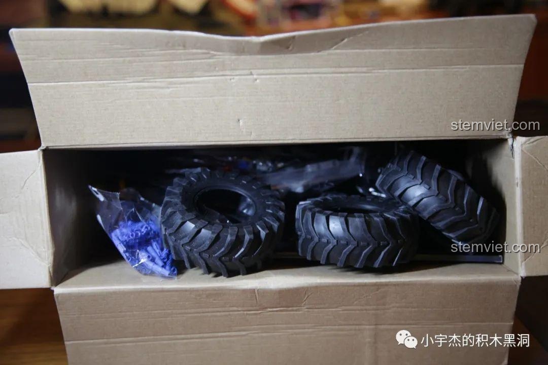 Bên trong hộp Happy Build XQ1212D chứa đầy các túi chi tiết và lốp xe, không có khay đựng riêng nhưng rất đầy đặn.