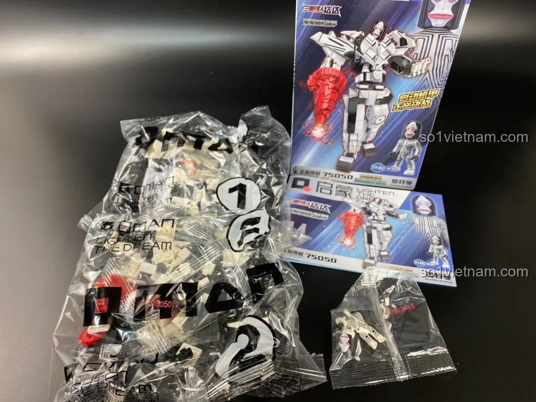 Bên trong hộp Qman 75050 Mecha Quái Nhân Ba Mặt Dada, gồm các túi chi tiết và sách hướng dẫn.