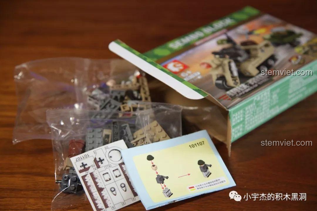 Mở hộp bộ lắp ráp Xe bán xích quân sự 101107, bên trong có túi chi tiết, sách hướng dẫn và một tấm sticker.