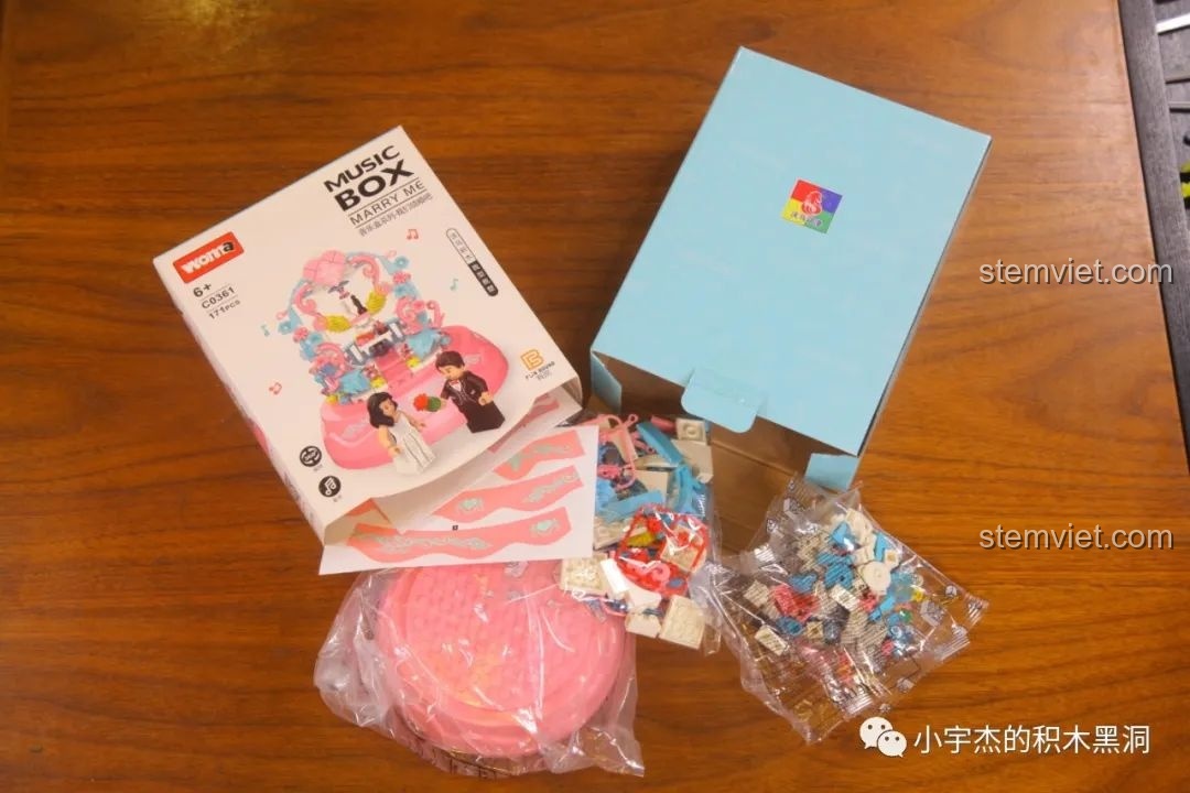 Mở hộp bộ lắp ráp hộp nhạc WOMA C0361 chủ đề đám cưới, bên trong có sách hướng dẫn, sticker, và các túi mảnh ghép.