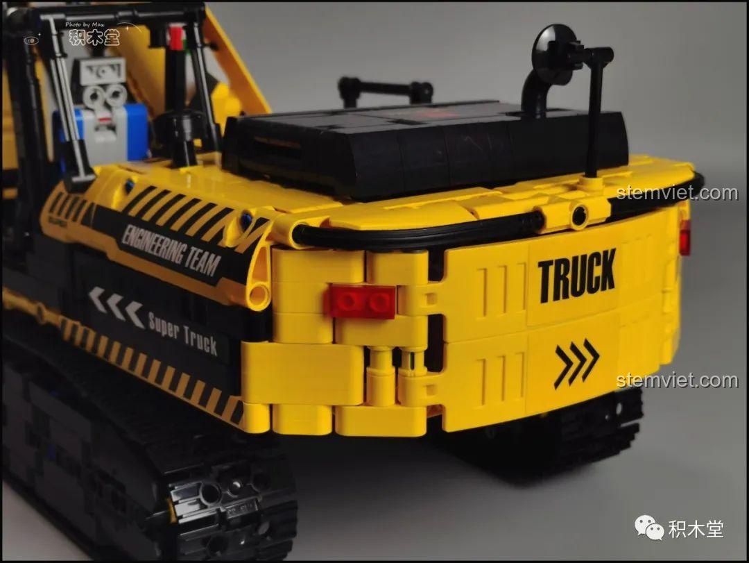 Hướng dẫn cách mở nắp đuôi máy xúc Taigaole T4001 để tiếp cận hộp pin.