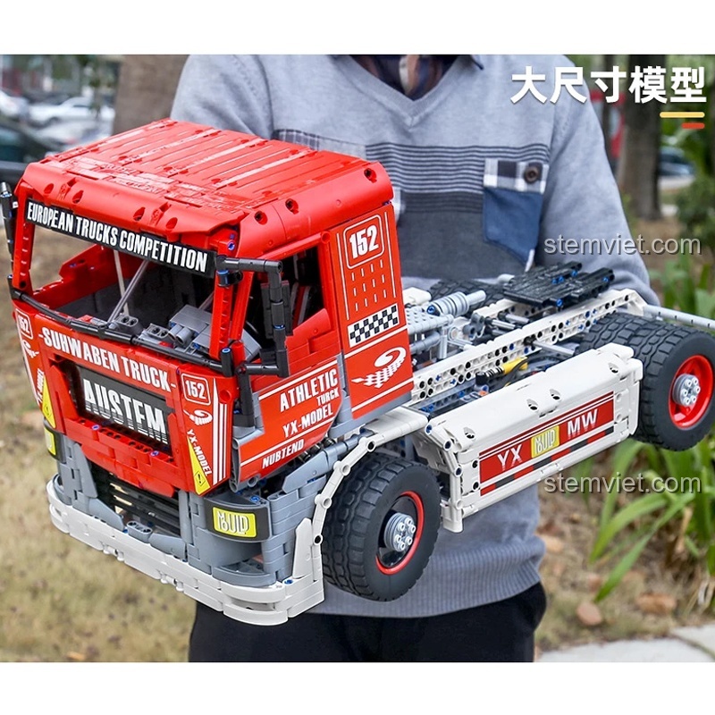 Hình ảnh thực tế kích thước lớn của bộ xếp hình 13152 Xe Tải Thi Đấu Châu Âu khi được một người lớn cầm trên tay, cho thấy sự hoành tráng của mô hình.