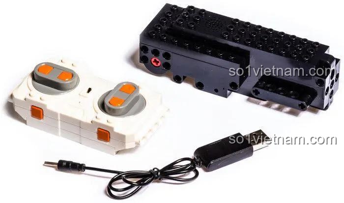 Bộ điều khiển từ xa và pin sạc đi kèm bộ lắp ráp Mould King 13153 Xe Địa Hình Lật Đổ Hai Mặt, đảm bảo trải nghiệm chơi liên tục và tiện lợi cho bé trai.