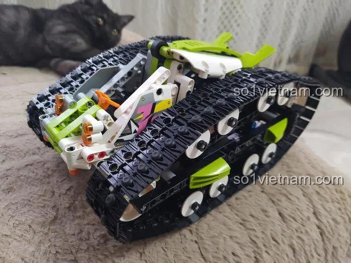Ảnh review đồ chơi lắp ráp Mould King 13153 Xe Đua Địa Hình Hai Mặt màu xanh lá, thể hiện chi tiết bánh xích và khả năng vượt địa hình, đồ chơi cho bé trai 8 tuổi.