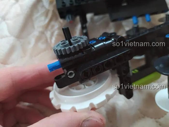 Chi tiết bánh răng và trục quay của đồ chơi mô hình Mould King 13153, minh họa khả năng điều khiển từ xa và tính năng lật đổ hai mặt, phù hợp bé trai 8 tuổi.