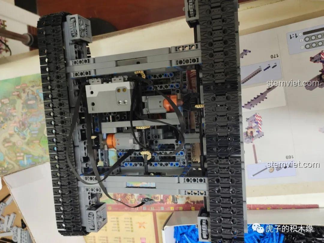 Phần đế của mô hình cần cẩu bánh xích Mould King 17002 với hệ thống bánh xích đã được lắp đặt, sẵn sàng cho khả năng di chuyển của đồ chơi mô hình công trình.