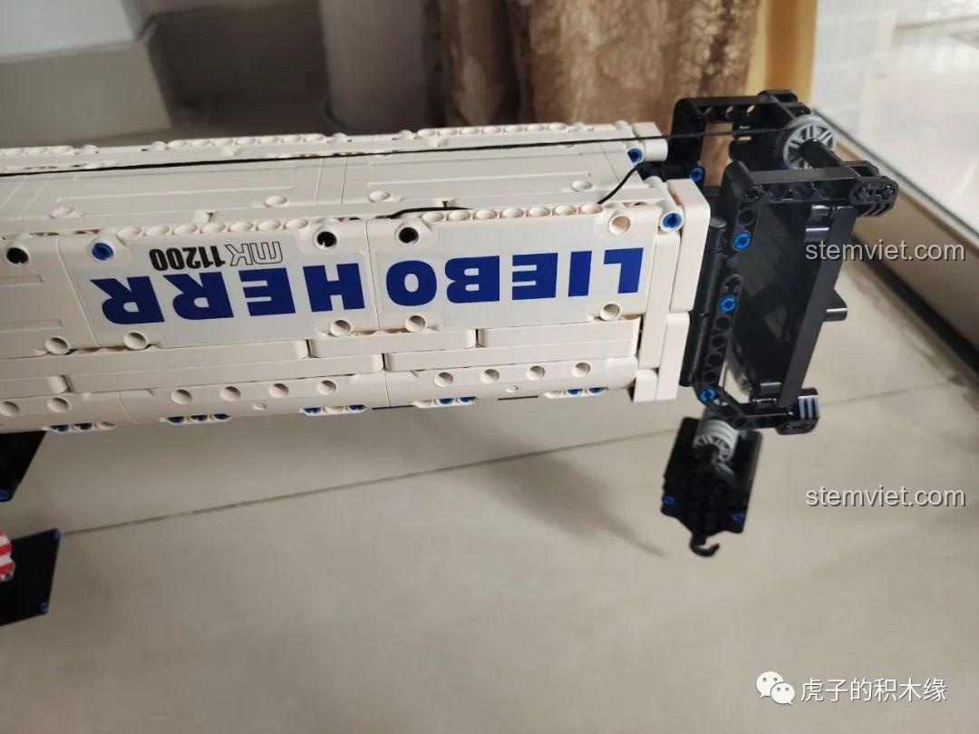 Mô hình cần cẩu bánh xích Liebherr LTR 11200 Mould King 17002 đã hoàn thành, nhìn từ bên cạnh, cho thấy cấu trúc vững chắc và các chân chống có thể điều chỉnh.
