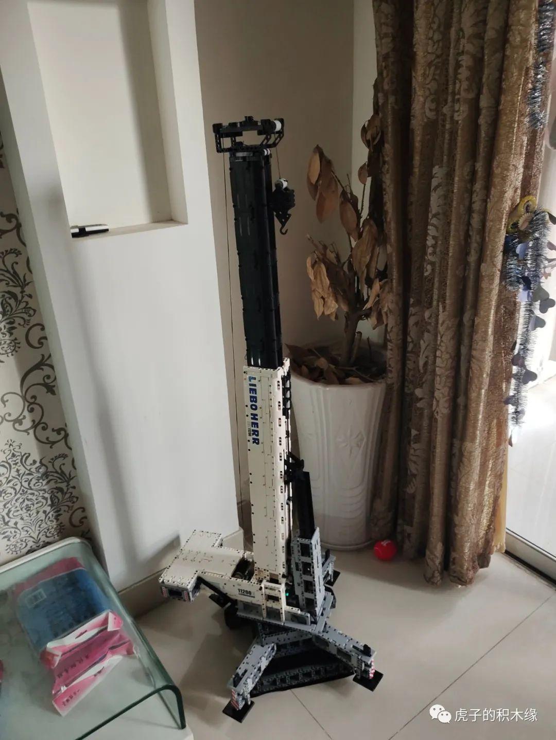 Mô hình cần cẩu bánh xích Liebherr LTR 11200 Mould King 17002 khổng lồ đang được đo chiều cao, thể hiện kích thước ấn tượng của bộ đồ chơi lắp ráp này, phù hợp cho bé trai 8 tuổi yêu thích kỹ thuật.