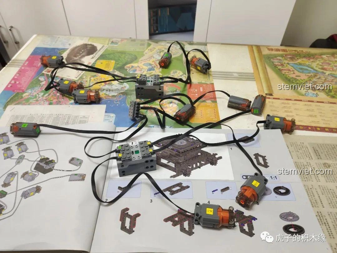 Chi tiết phần đế của mô hình cần cẩu Mould King 17002 đang trong quá trình lắp ráp, với các motor và dây điện được bố trí.