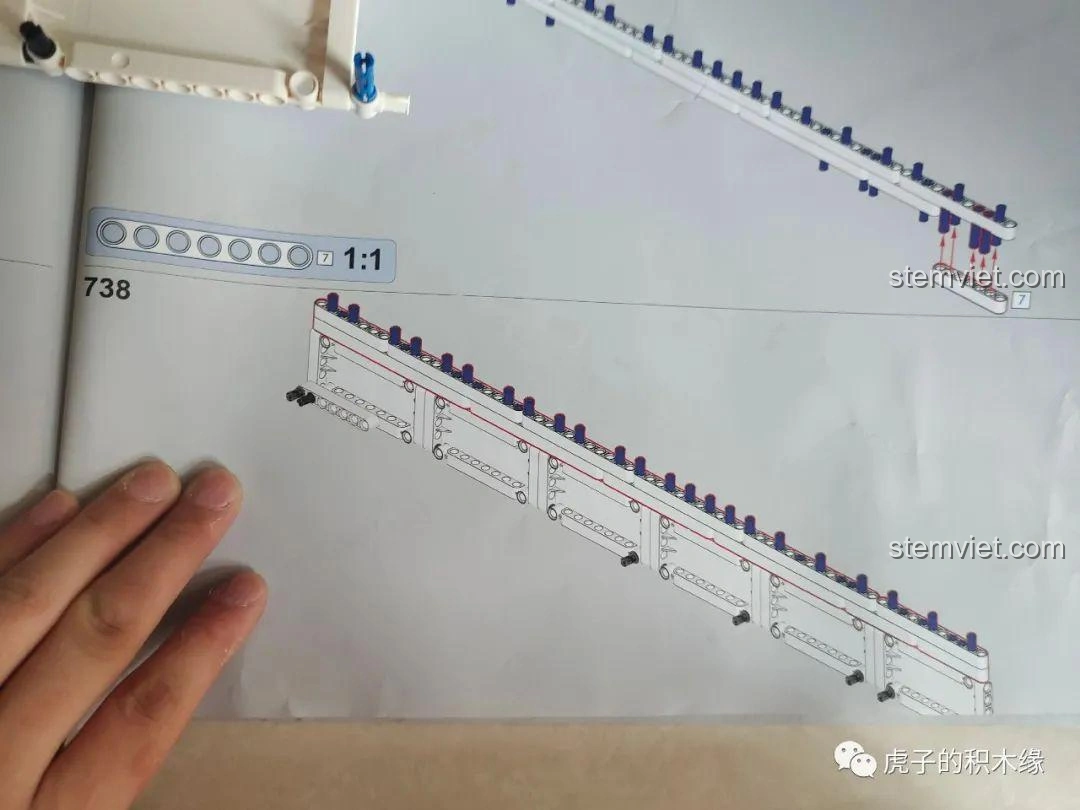Cần cẩu lớn của mô hình Mould King 17002 được đặt lên cân, cho thấy trọng lượng đáng kể của bộ phận này.