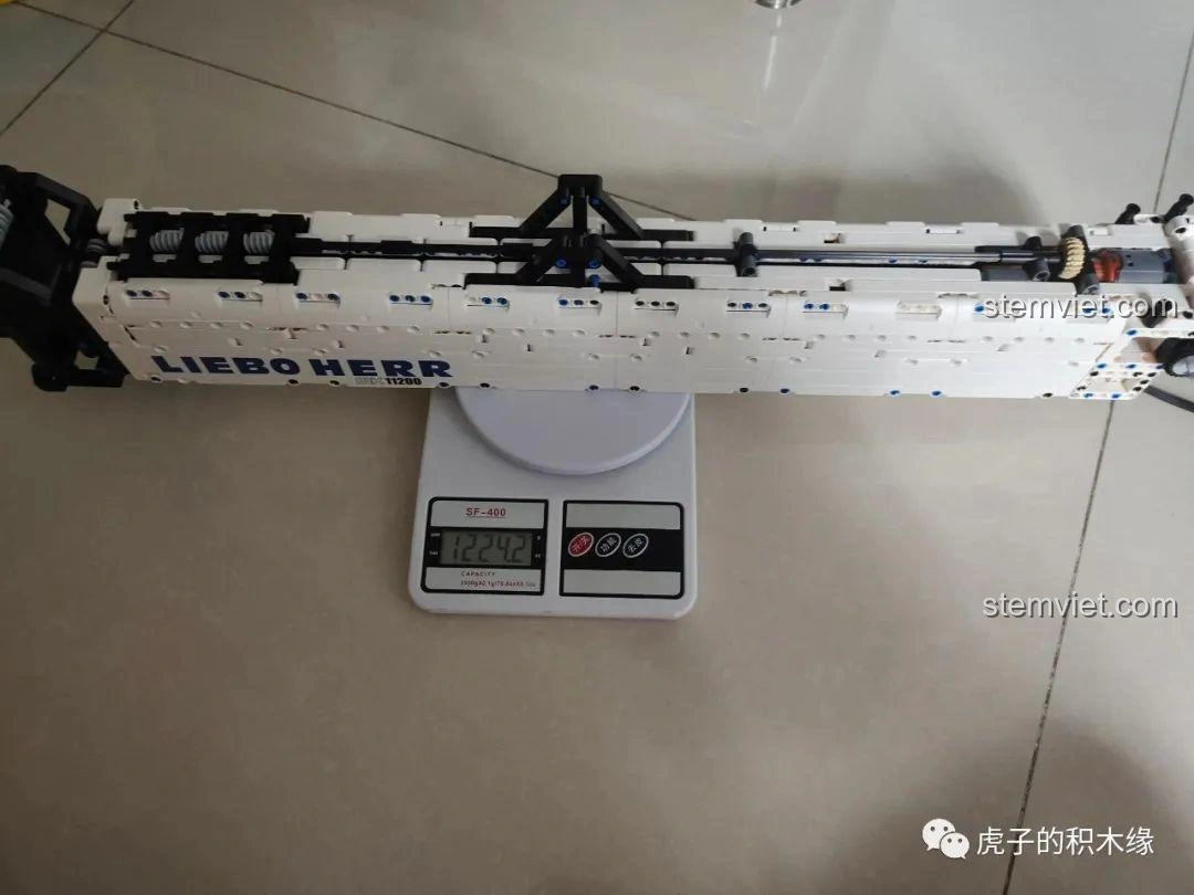 Mô hình cần cẩu bánh xích Mould King 17002 Liebherr LTR 11200 đã hoàn thiện, đặt trên sàn nhà, thể hiện kích thước ấn tượng.