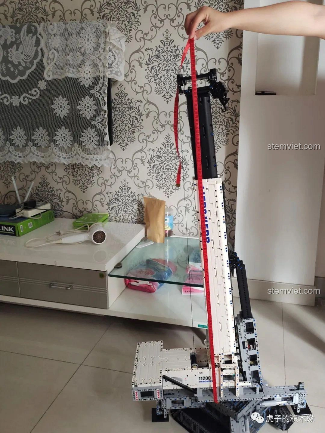 Mô hình cần cẩu bánh xích Mould King 17002 Liebherr LTR 11200 đã hoàn thiện, đặt trên sàn nhà, sẵn sàng hoạt động.