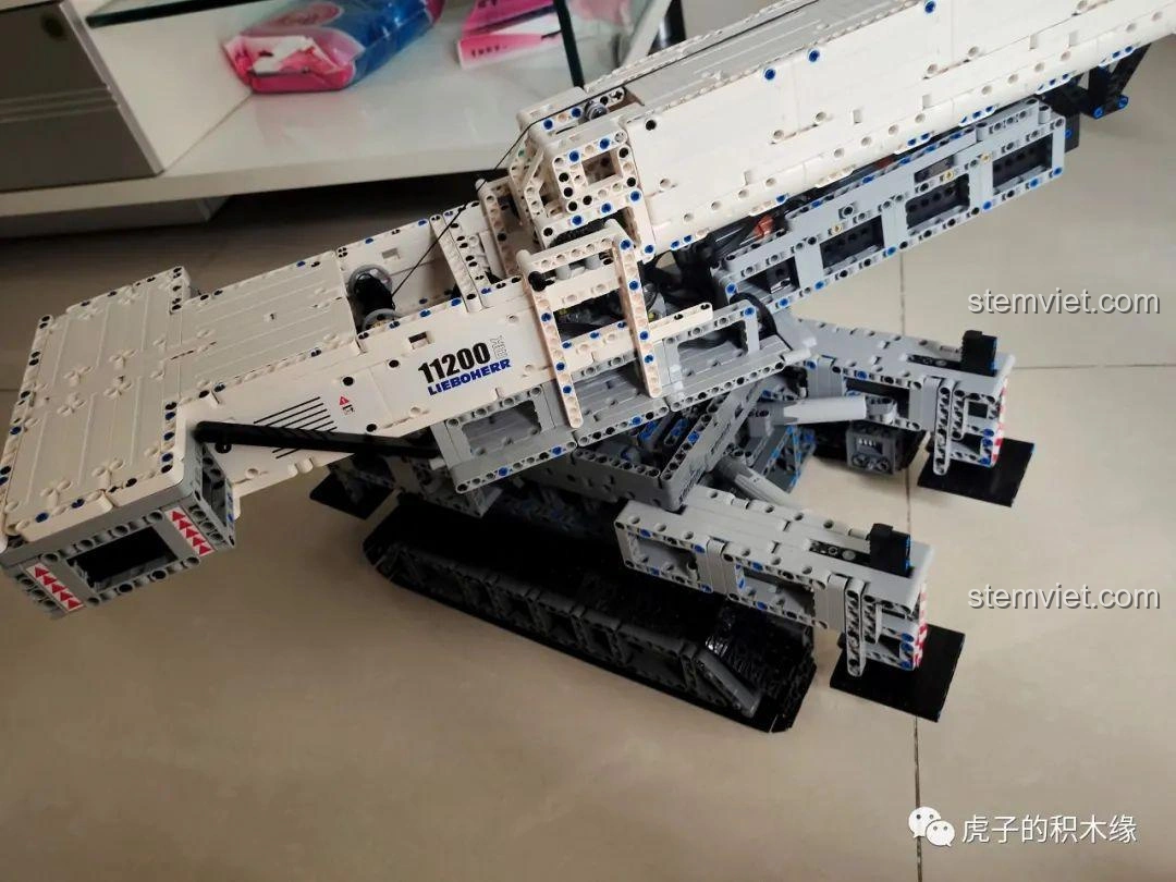 Mô hình cần cẩu bánh xích Mould King 17002 Liebherr LTR 11200 đã hoàn thiện, đặt trên sàn nhà, sẵn sàng hoạt động.