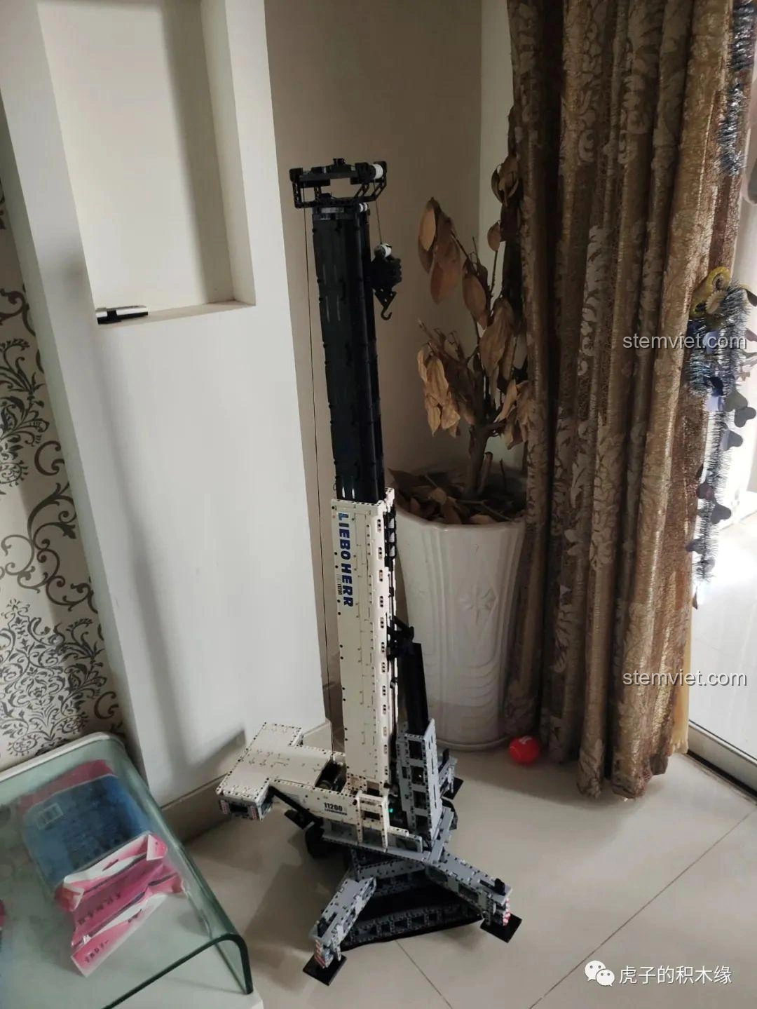 Mô hình cần cẩu bánh xích Mould King 17002 Liebherr LTR 11200 đã hoàn thiện, đặt trên sàn nhà, sẵn sàng hoạt động.