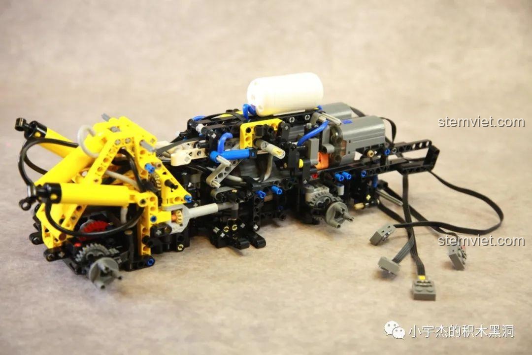 Hệ thống khí nén của xe xúc lật khí nén Mould King 17026 Liebherr L550 đang được lắp đặt, cho thấy cơ chế hoạt động chân thực của đồ chơi xây dựng này.