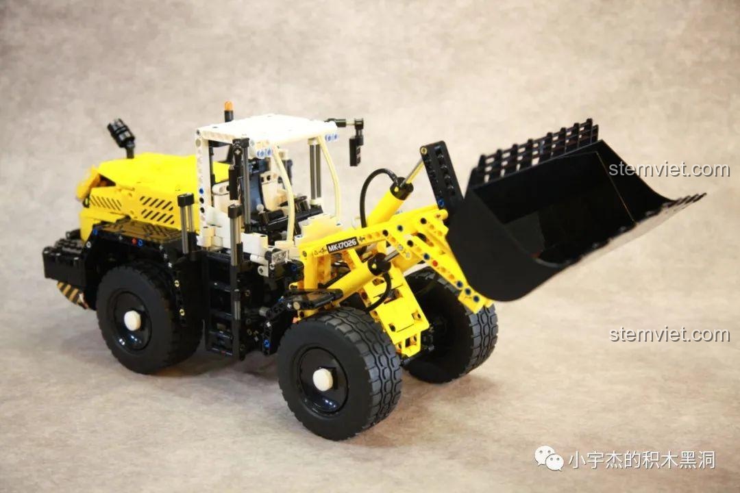 Xe xúc lật khí nén Mould King 17026 Liebherr L550 đang thực hiện thao tác nâng gầu bằng hệ thống khí nén, thể hiện tính năng độc đáo của đồ chơi mô hình công trình.