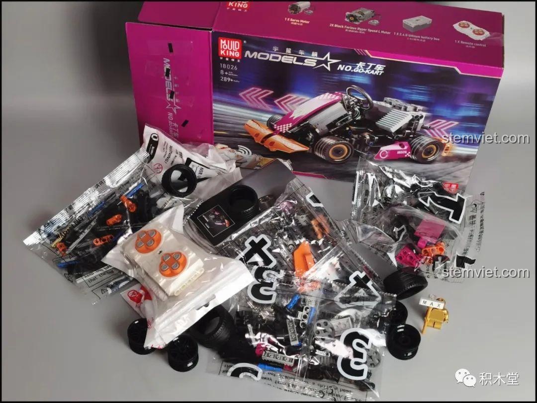 Toàn bộ linh kiện bên trong hộp Mould King 18026 Xe Kart Điều Khiển Từ Xa, bao gồm các túi mảnh ghép và bộ điều khiển.