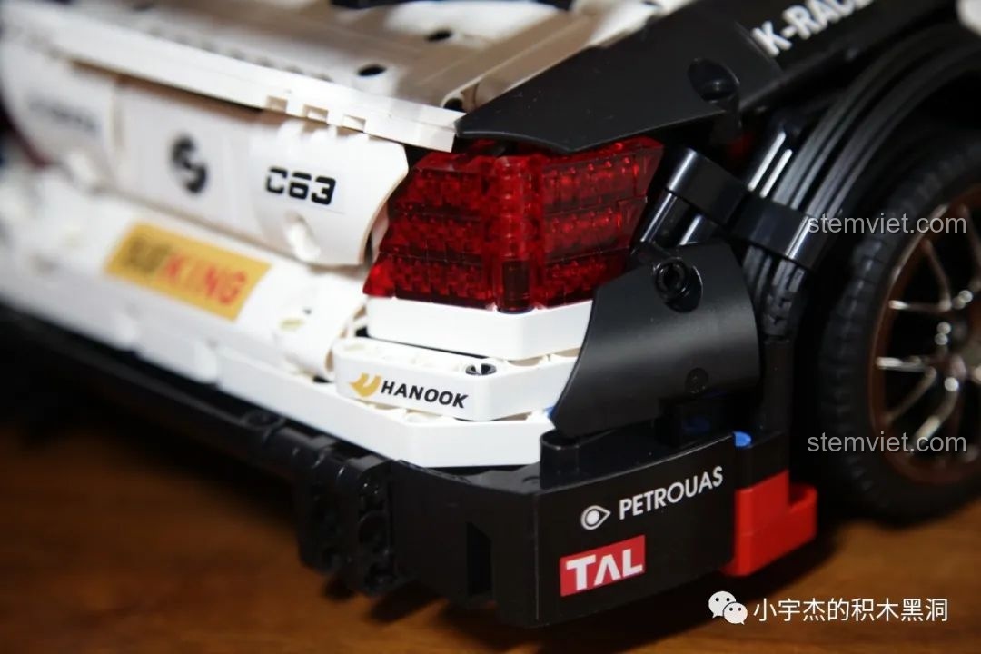 Hai mô hình Mould King Mercedes-Benz AMG C63 DTM màu trắng và xanh đặt cạnh nhau, chụp ở góc nghiêng.