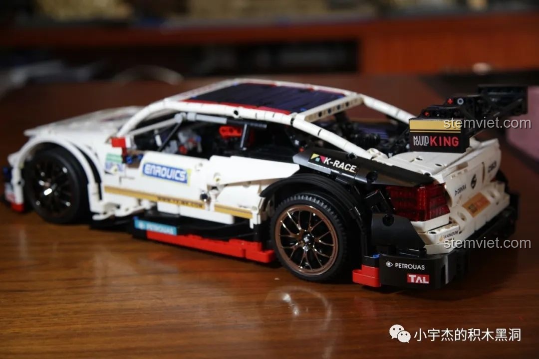 Hai mô hình Mould King Mercedes-Benz AMG C63 DTM màu trắng và xanh đặt cạnh nhau, nhìn từ trên xuống phía sau.