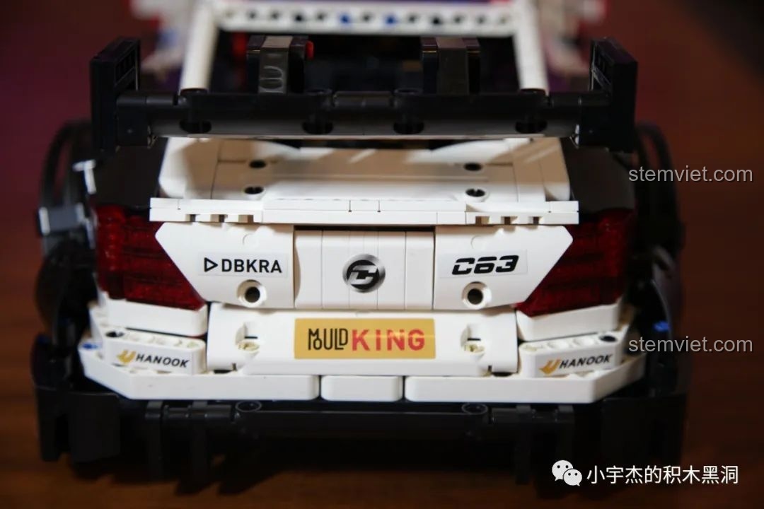 Hai mô hình Mould King Mercedes-Benz AMG C63 DTM màu trắng và xanh đặt cạnh nhau, nhìn từ trên xuống.