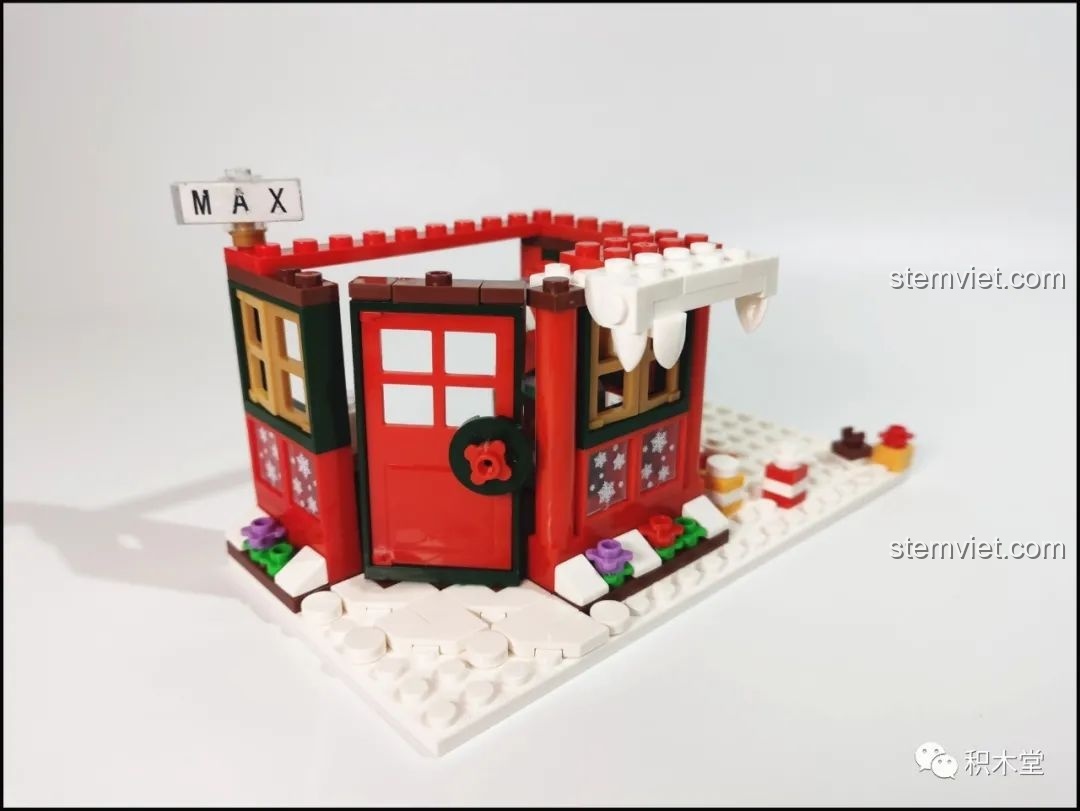 Ngôi nhà Giáng Sinh của bộ Forange FC6003 đang dần hoàn thiện, với mái nhà phủ tuyết và cửa đỏ.