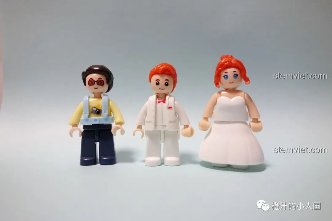 Ba nhân vật minifigures trong bộ đồ chơi lắp ráp Xe Limousine đám cưới 767: cô dâu, chú rể và thợ chụp ảnh.