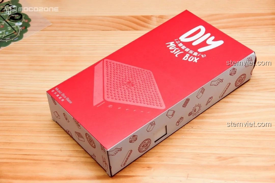 Hộp nhỏ màu đỏ chứa đế nhạc của bộ đồ chơi Hộp nhạc Giáng Sinh Xoay Tự Động JAKI JK1365, với dòng chữ