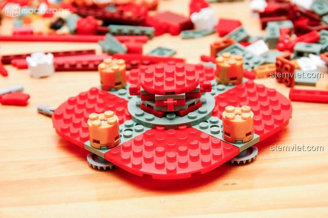 Quá trình lắp ráp phần đế của Hộp nhạc Giáng Sinh Xoay Tự Động JAKI JK1365, các mảnh ghép màu đỏ và xanh lá cây được kết nối chặt chẽ.