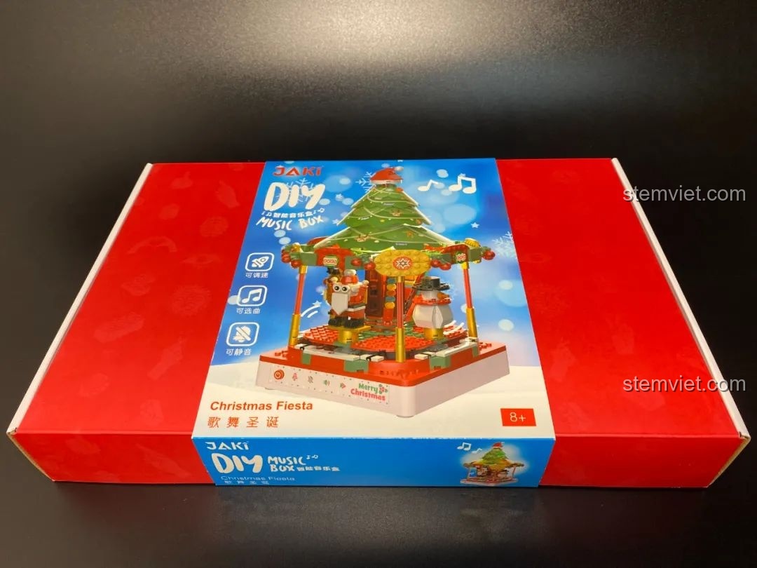 Bao bì Hộp nhạc Giáng Sinh Xoay Tự Động JAKI JK1365 với hình ảnh cây thông và các nhân vật Giáng Sinh. Món đồ chơi lắp ráp Giáng Sinh có nhạc.
