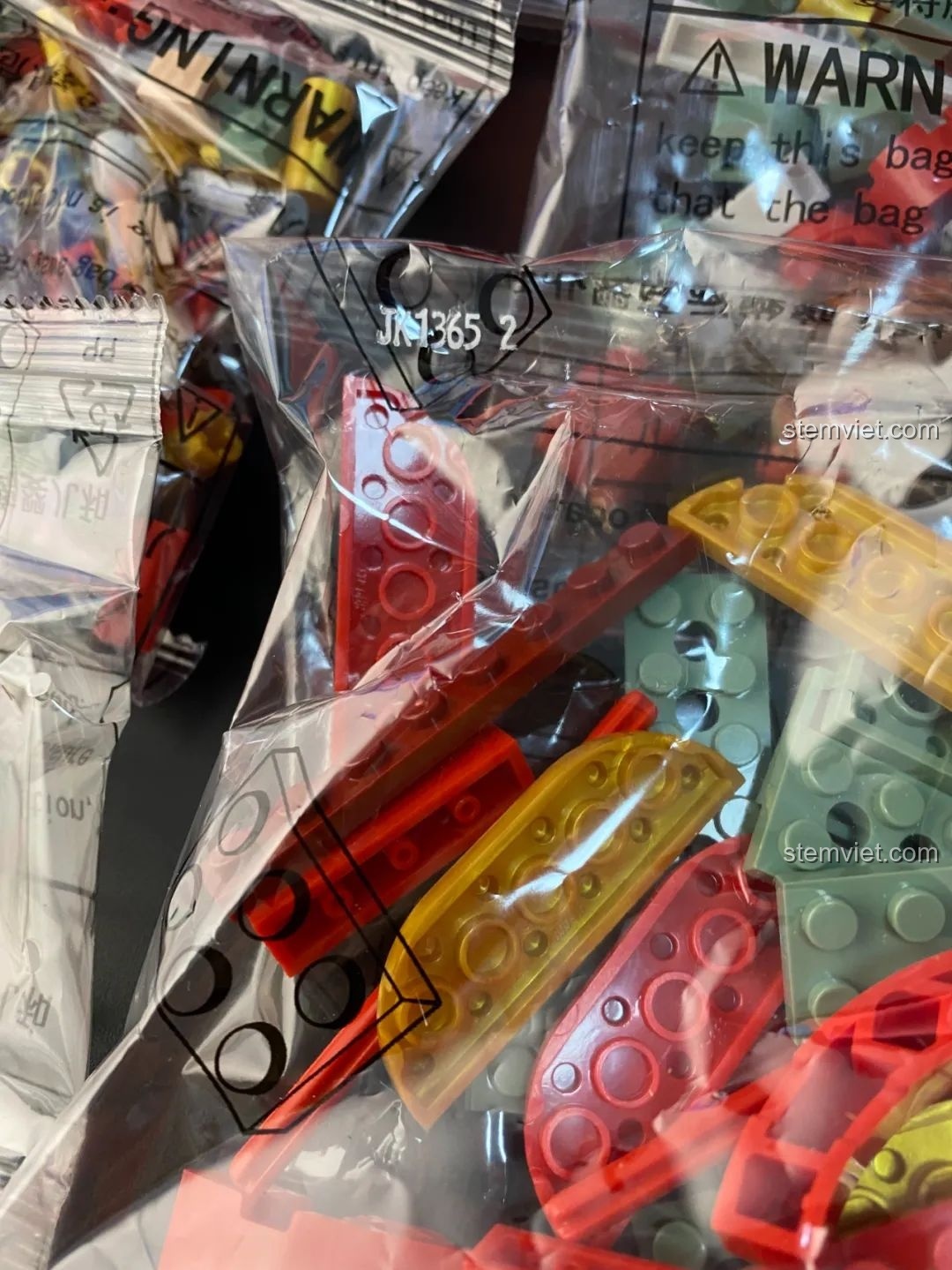 Cận cảnh các túi mảnh ghép của Hộp nhạc Giáng Sinh Xoay Tự Động JAKI JK1365, được đánh số rõ ràng. Đồ chơi lắp ráp Giáng Sinh có nhạc.