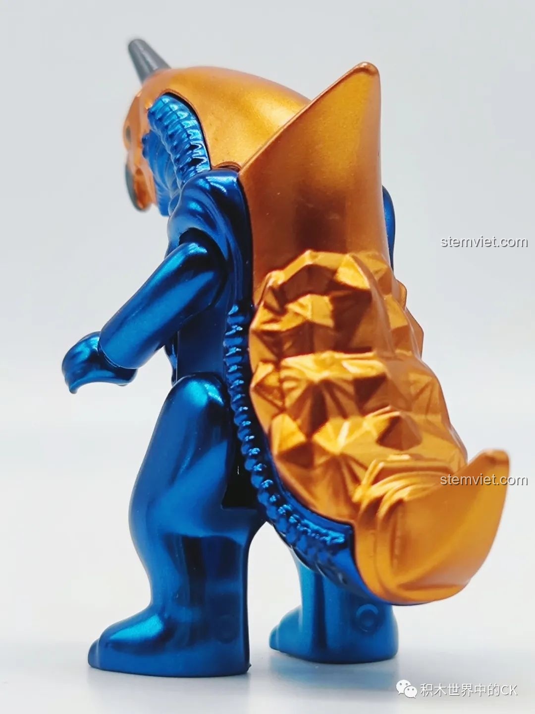 Mặt sau của mô hình quái vật Baxim 75026-11, cho thấy chi tiết vảy và đuôi. Nhận xét QMAN 026 Ultraman Thế hệ Reiwa.