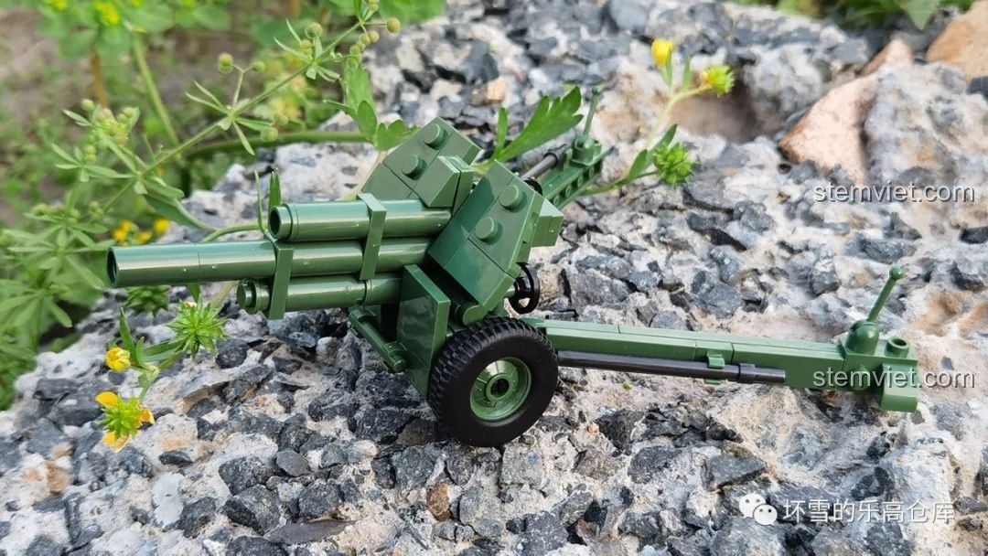 Mô hình pháo M-30 QUANGUAN 122mm đặt trên nền đá với cây cỏ xung quanh, thể hiện bối cảnh tự nhiên. Nhận xét QUANGUAN 100078 Pháo cao xạ.