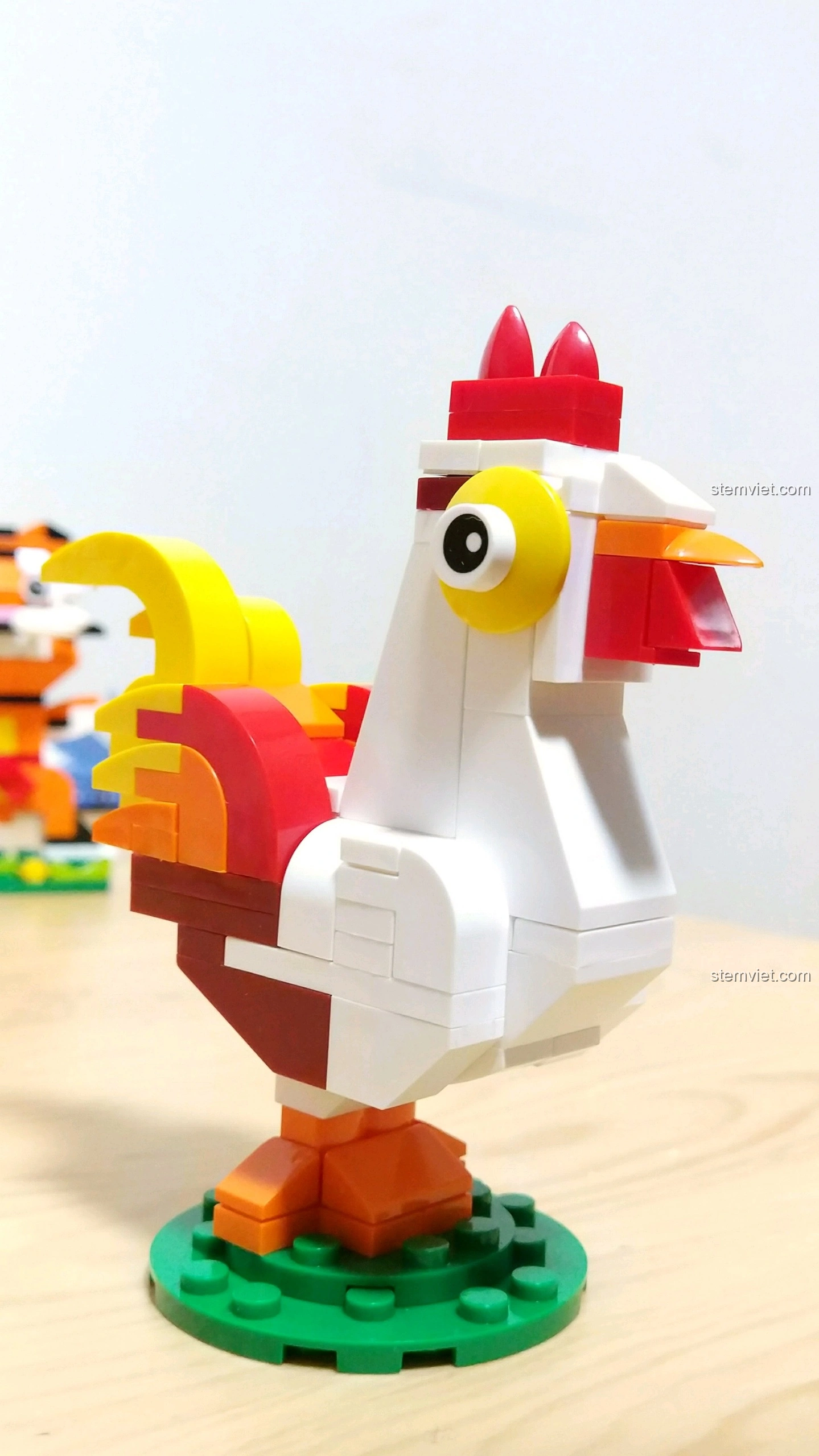 Góc nghiêng của mô hình Gà Dậu, cho thấy chi tiết mào đỏ, mắt vàng và các lớp màu sắc trên thân.