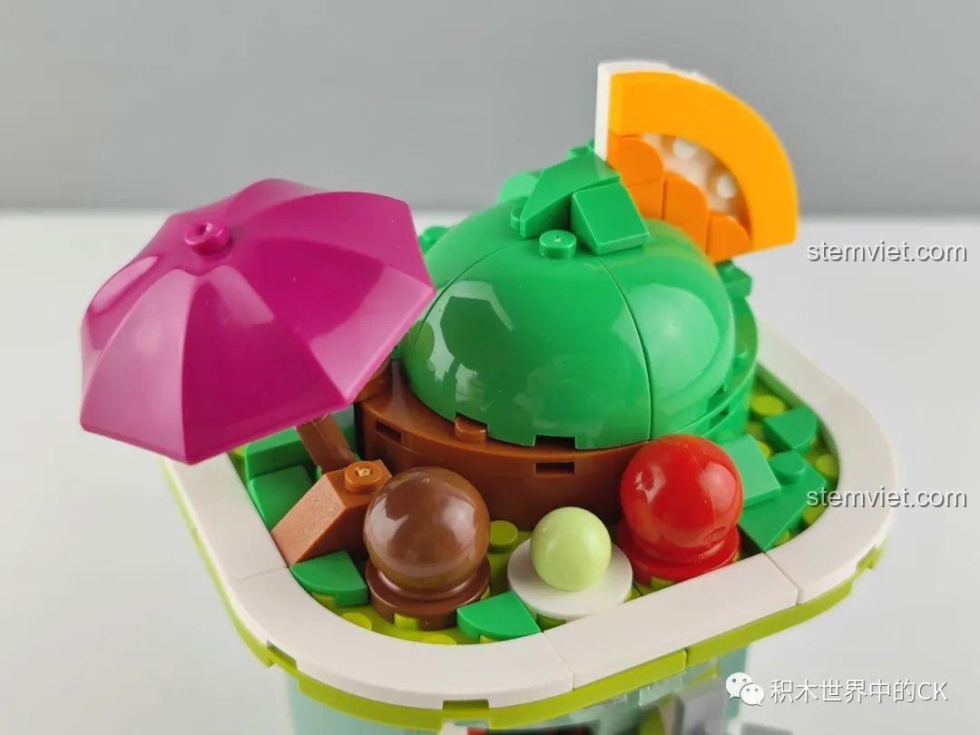 Phần nóc của mô hình Cửa hàng Matcha Zhe Gao CW6005, với chiếc ô màu hồng và các loại trái cây trang trí.