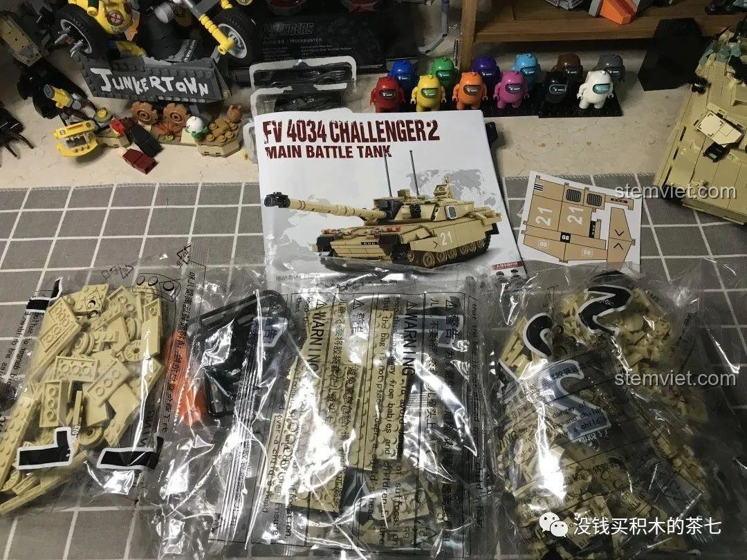 Nội dung bên trong hộp bộ đồ chơi lắp ráp Xe Tăng Challenger 2 FV 4034 JIAZHI 0105, bao gồm các túi chi tiết, sách hướng dẫn và decal.