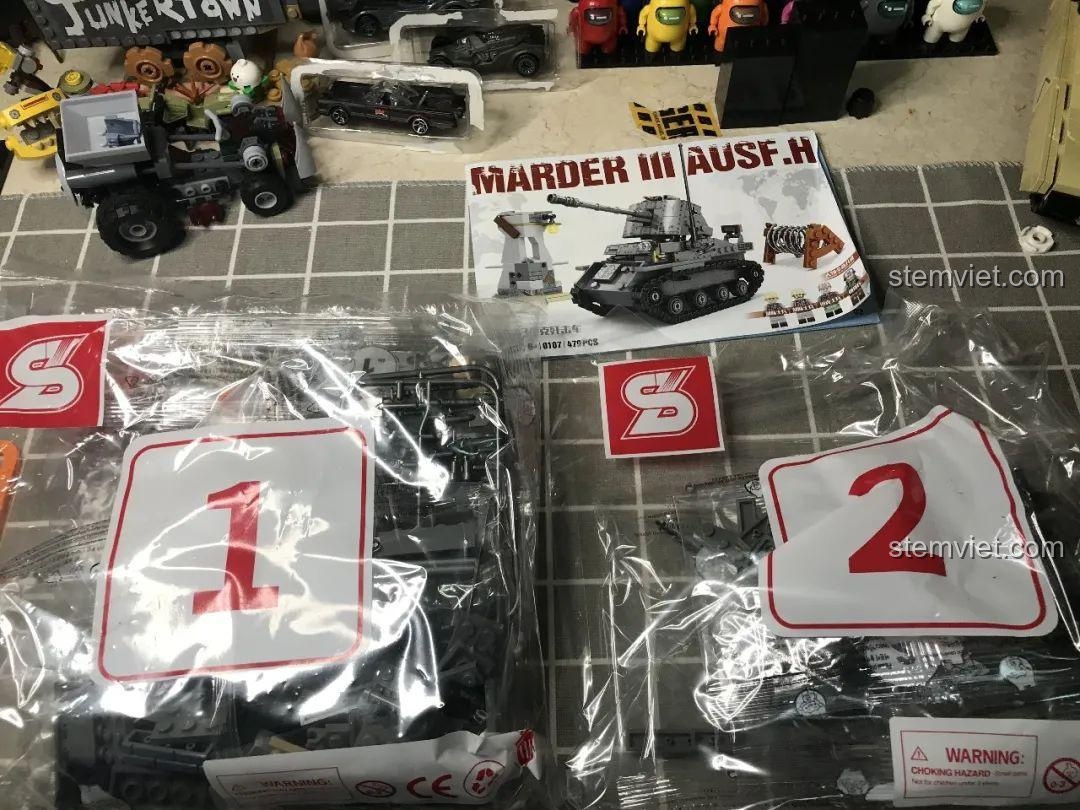Toàn bộ nội dung bên trong hộp bộ đồ chơi lắp ráp JiaZhi 0107 Marder III Ausf.H, bao gồm các túi mảnh ghép, sách hướng dẫn và decal, chuẩn bị cho trải nghiệm JiaZhi 107 Xe tăng diệt Marder III.