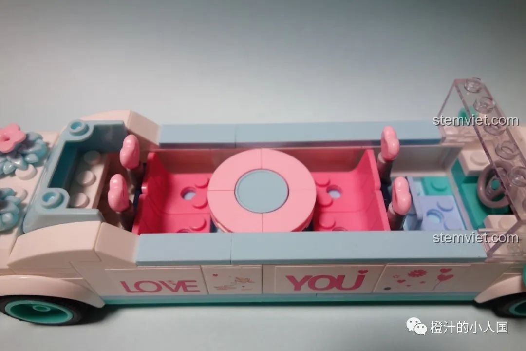 Nội thất bên trong của đồ chơi mô hình xe cưới M38-B0767 với bàn tròn và ghế ngồi màu hồng.