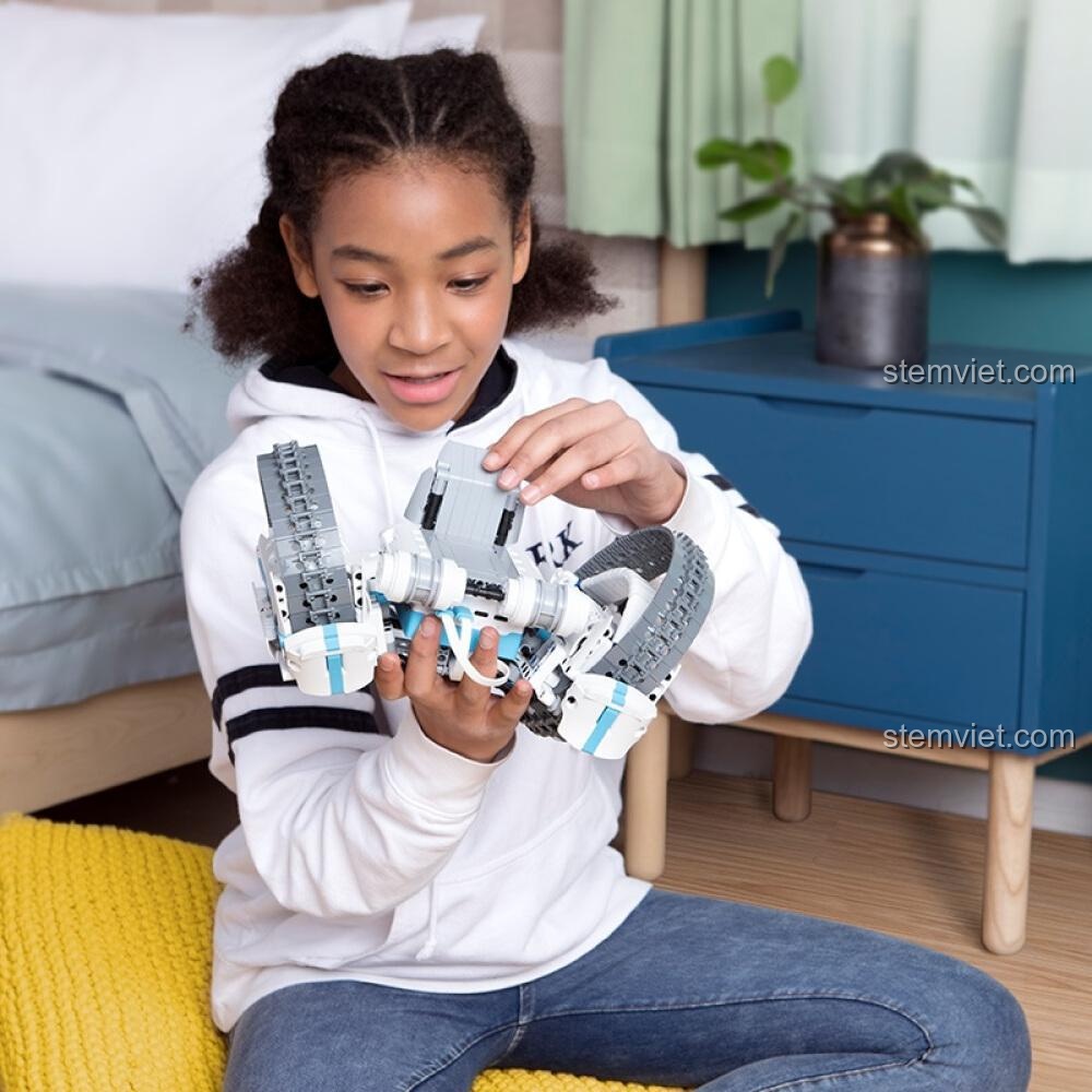 Bé gái thích thú khám phá bộ lắp ráp Robot Điều Khiển Từ Xa ONEBOT, món quà tuyệt vời cho các bé đam mê công nghệ.