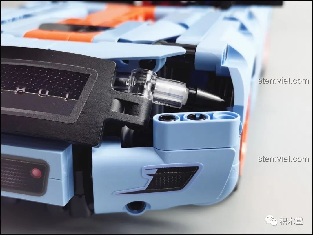 Cận cảnh bánh xe màu cam và lốp cao su của mô hình ONEBOT OBJBY61AIQI Siêu Xe Bu Yun, với chữ V8.