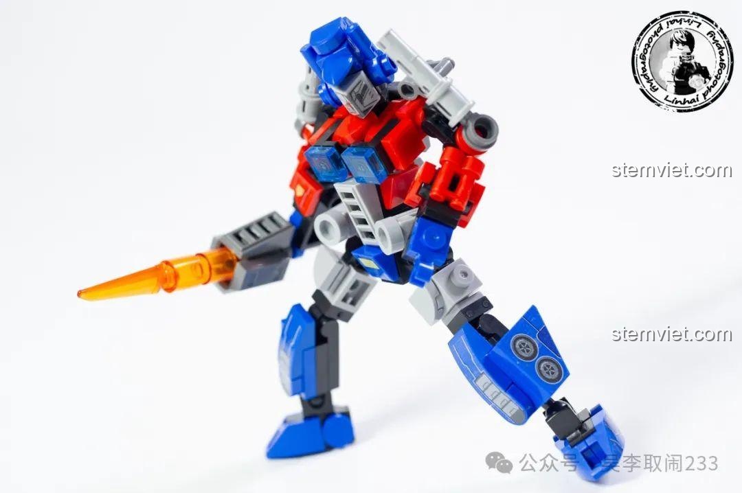 Robot Optimus Prime cầm thanh kiếm năng lượng, tạo dáng chiến đấu đầy mạnh mẽ.