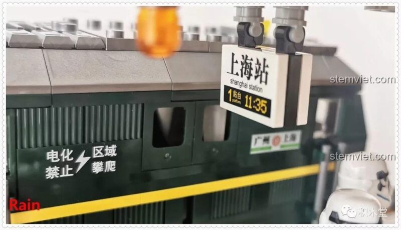 Đồng hồ trên sân ga hiển thị 11:35, khớp với đồng hồ trên tàu, một chi tiết tinh tế trong bộ lắp ghép Tàu hỏa xanh lá cây Panlos Brick 610008.