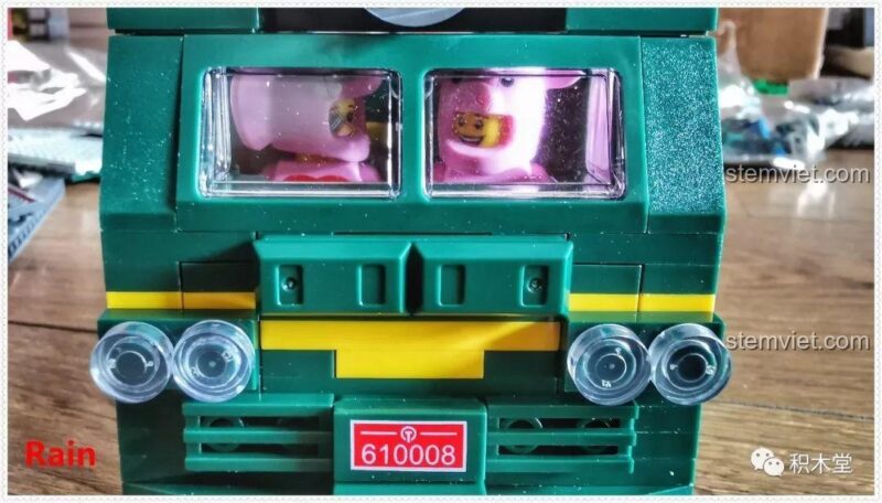 Minifigure ngồi trong buồng lái tàu hỏa xanh lá cây Panlos Brick 610008, thể hiện không gian rộng rãi cho 2 nhân vật.