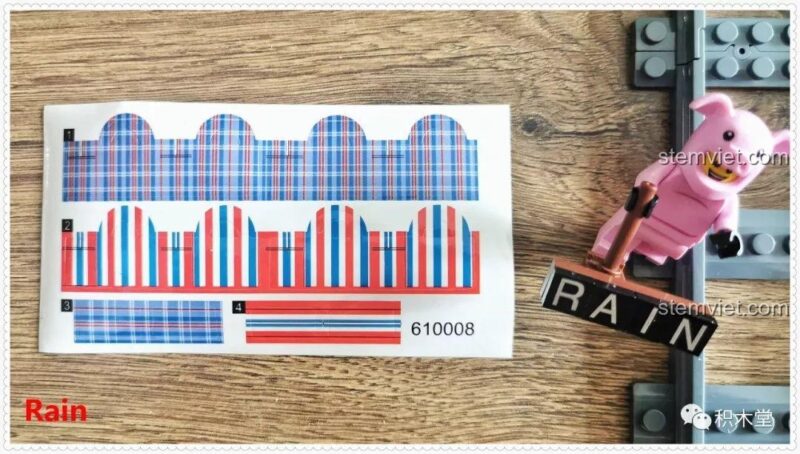 Tấm sticker độc đáo và minifigure trong bộ xếp hình Cảnh ga tàu hỏa Panlos Brick 610008, với chi tiết túi xách đỏ trắng xanh ấn tượng.